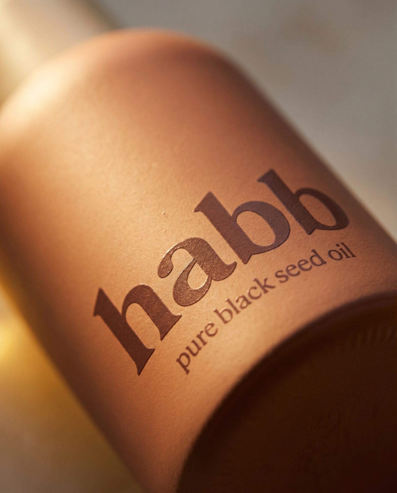 macro of habb wordmark on terracotta bottle